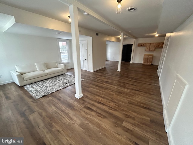 unfurnished living room featuring dark wood finished floors, visible vents, and baseboards