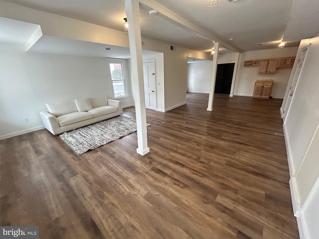 unfurnished living room with dark wood finished floors, visible vents, and baseboards