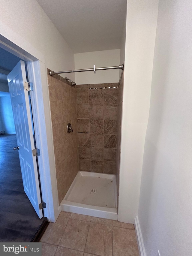 full bathroom featuring tile patterned flooring and a shower stall