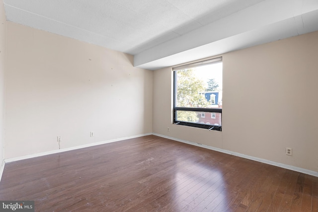 unfurnished room with dark hardwood / wood-style flooring