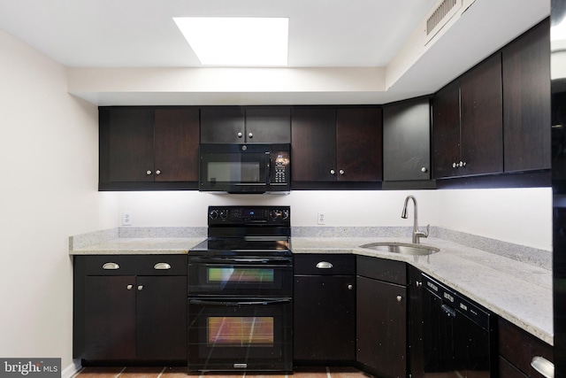 kitchen featuring dark brown cabinets, black appliances, sink, and light stone counters