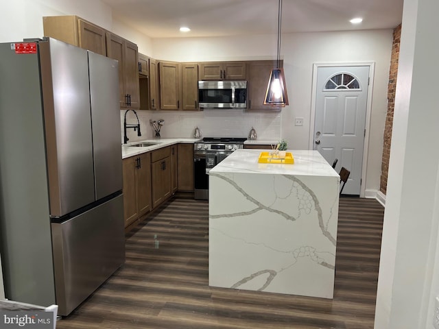 kitchen featuring tasteful backsplash, sink, stainless steel appliances, pendant lighting, and dark hardwood / wood-style floors