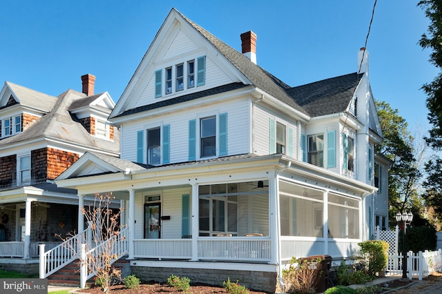 view of front of home featuring covered porch and a sunroom