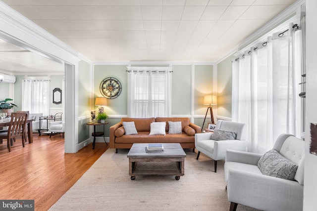 living room featuring ornamental molding, a wall mounted air conditioner, and hardwood / wood-style flooring