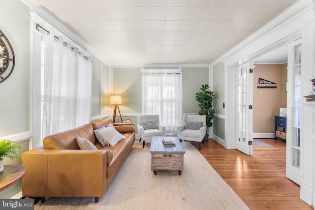 living room with ornamental molding, french doors, and light hardwood / wood-style floors