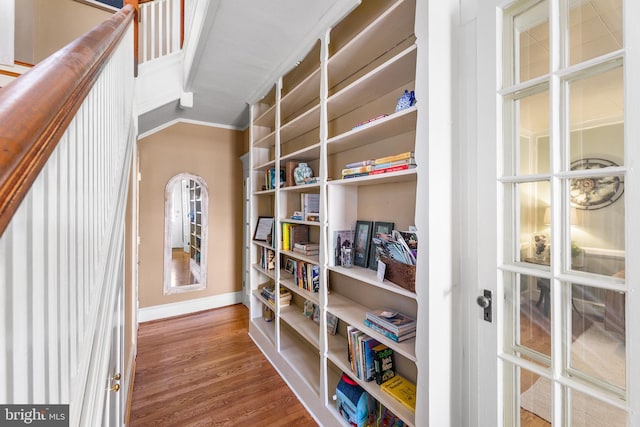 interior space featuring lofted ceiling, hardwood / wood-style floors, and crown molding