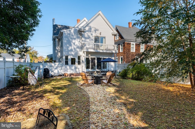 rear view of property with a patio and a balcony