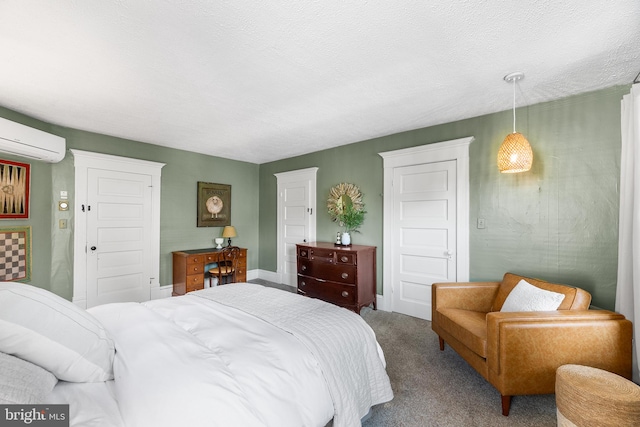 bedroom featuring a textured ceiling, a wall mounted AC, and carpet flooring