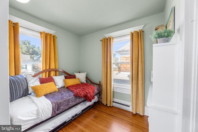 bedroom featuring baseboard heating and wood-type flooring