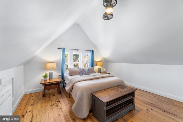 bedroom with light hardwood / wood-style floors and lofted ceiling