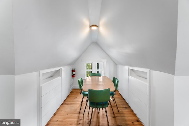 dining space with light hardwood / wood-style flooring and lofted ceiling