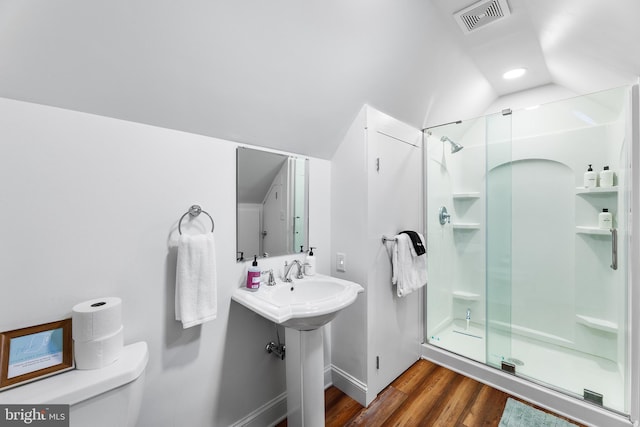 bathroom with vaulted ceiling, hardwood / wood-style flooring, toilet, and an enclosed shower