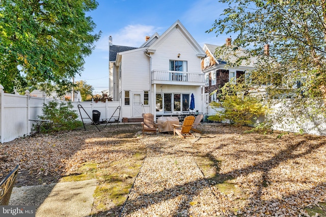 back of property with a balcony