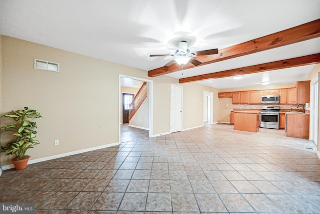 unfurnished living room with light tile patterned flooring, beam ceiling, ceiling fan, and sink