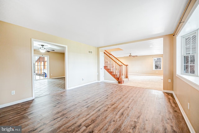 unfurnished living room featuring ceiling fan, a healthy amount of sunlight, and hardwood / wood-style flooring