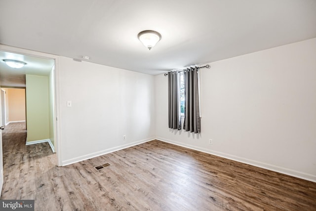 unfurnished room with hardwood / wood-style flooring