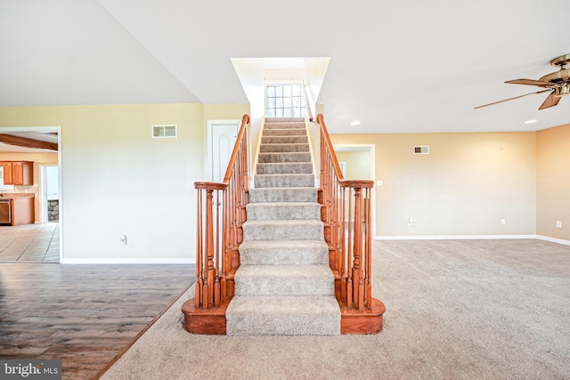 stairs featuring hardwood / wood-style floors, ceiling fan, and lofted ceiling