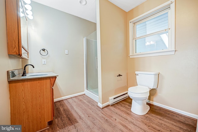 bathroom featuring vanity, baseboard heating, a shower with door, hardwood / wood-style flooring, and toilet