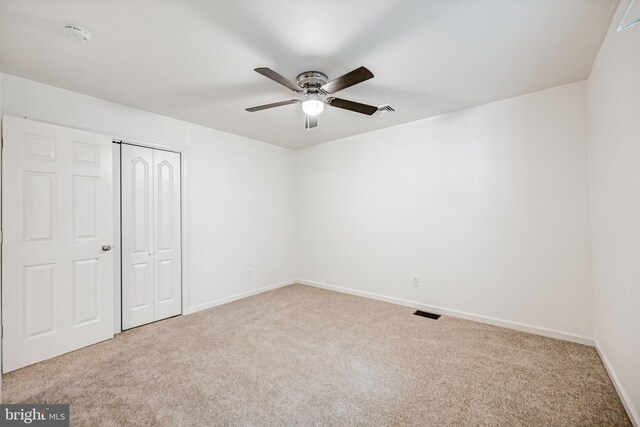 unfurnished bedroom with carpet, a closet, and ceiling fan