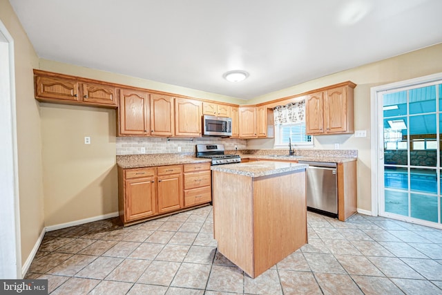 kitchen with light stone countertops, stainless steel appliances, a kitchen island, tasteful backsplash, and light tile patterned flooring