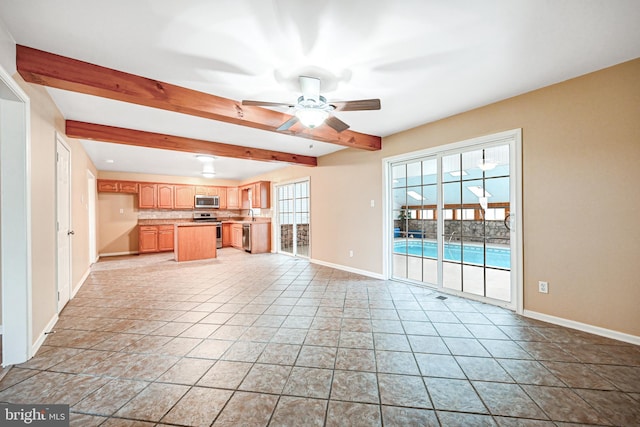 unfurnished living room featuring beamed ceiling, plenty of natural light, ceiling fan, and light tile patterned flooring