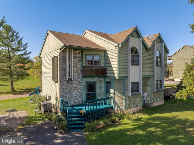 view of front of property featuring a front lawn, a deck, and central AC unit