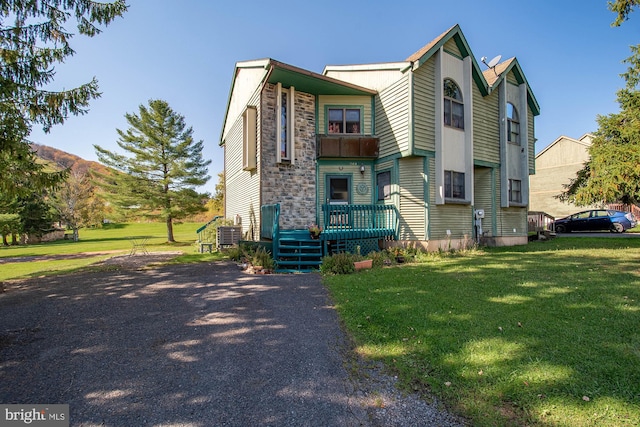 view of front of house featuring central air condition unit and a front yard