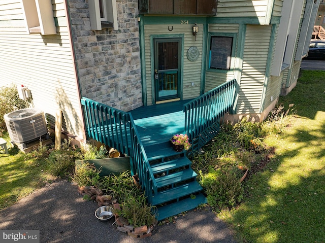 property entrance with a yard and central AC unit