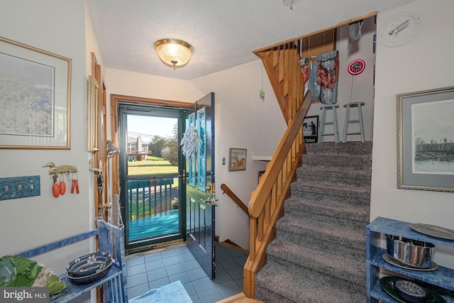 entrance foyer featuring a textured ceiling and light tile patterned flooring