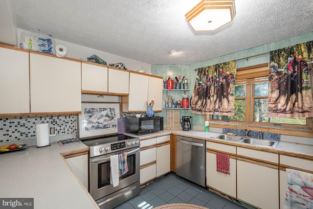 kitchen featuring appliances with stainless steel finishes, sink, backsplash, a textured ceiling, and white cabinets