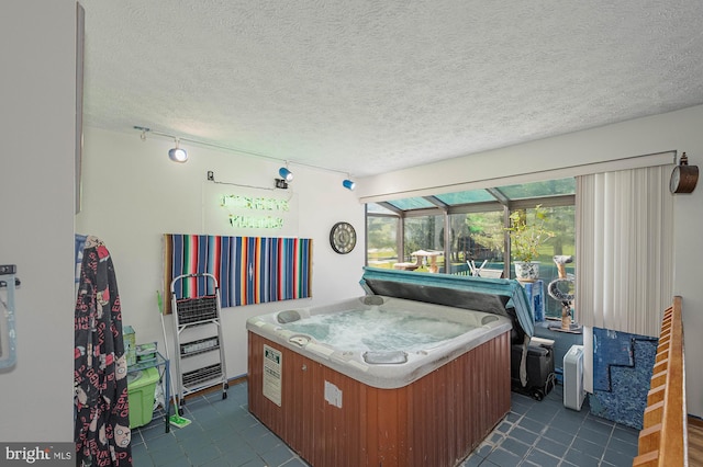 interior space featuring dark tile patterned floors, a textured ceiling, and a jacuzzi