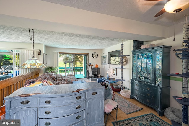 kitchen with gray cabinets, light hardwood / wood-style flooring, a textured ceiling, and ceiling fan