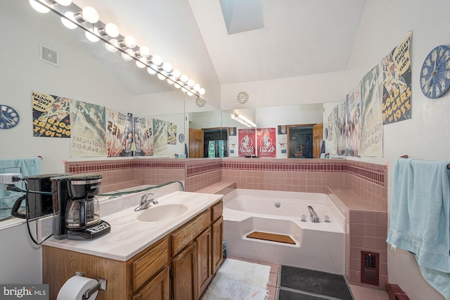 bathroom with vanity, tile patterned floors, lofted ceiling, and a washtub