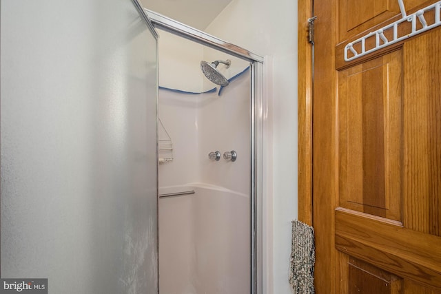 bathroom with a shower with door