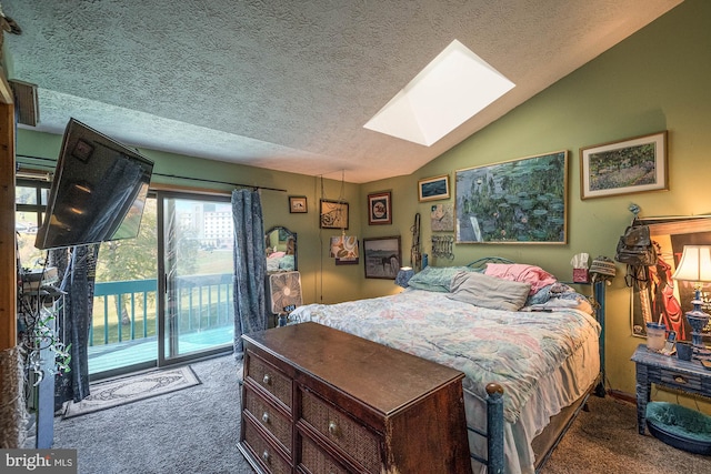 carpeted bedroom with vaulted ceiling with skylight, a textured ceiling, and access to exterior