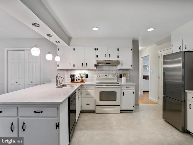 kitchen featuring kitchen peninsula, hanging light fixtures, sink, stainless steel fridge, and electric stove