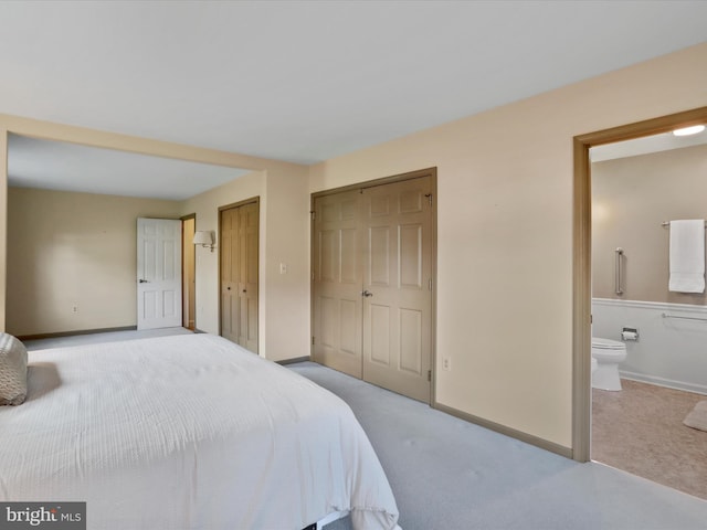 carpeted bedroom featuring ensuite bath