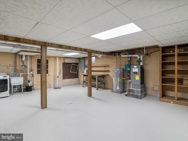 basement with washer / dryer, water heater, sink, and heating unit