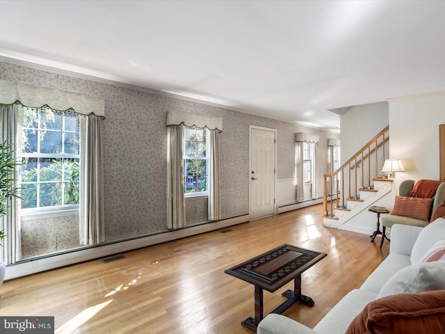 living room with crown molding, a baseboard radiator, and hardwood / wood-style floors