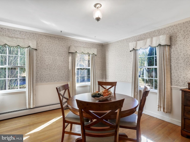 dining room featuring a wealth of natural light, ornamental molding, and light hardwood / wood-style flooring