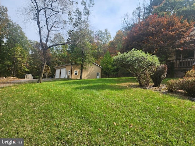 view of yard featuring a storage unit, a garage, and a deck