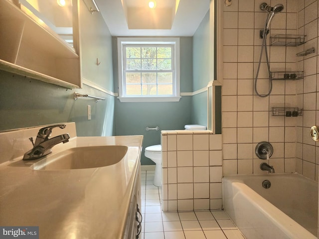 full bathroom featuring toilet, tiled shower / bath, vanity, and tile patterned floors