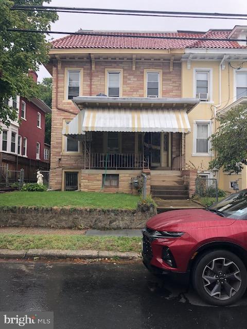 view of front of home with a tile roof and a porch