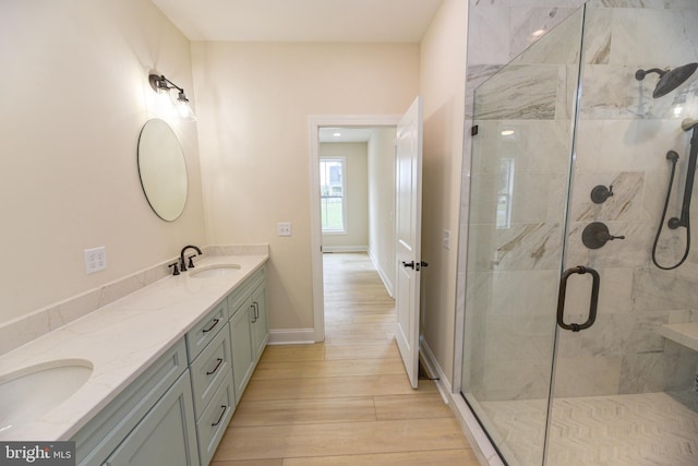 bathroom featuring vanity, hardwood / wood-style flooring, and a shower with door