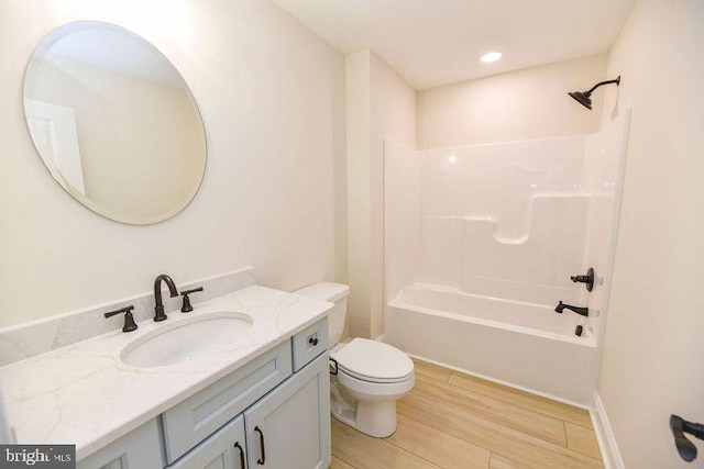 full bathroom with vanity, shower / washtub combination, hardwood / wood-style flooring, and toilet