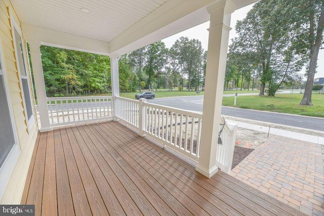 wooden terrace with a porch and a lawn