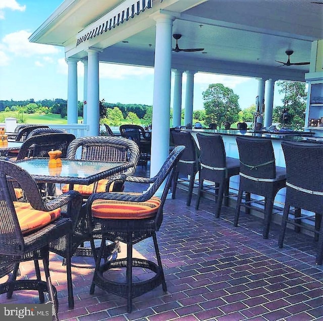 view of patio featuring ceiling fan and a bar