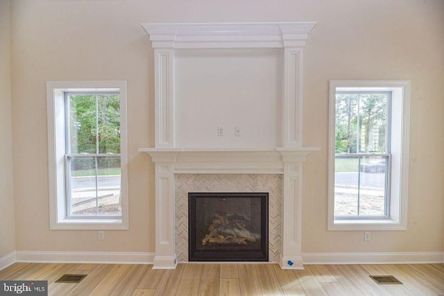 room details with hardwood / wood-style floors and a tiled fireplace