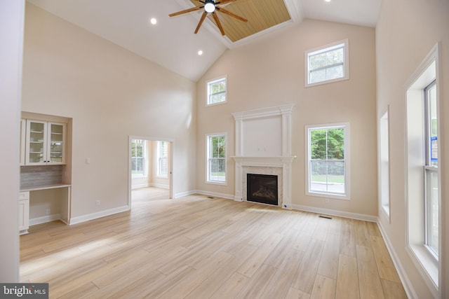 unfurnished living room featuring light hardwood / wood-style floors, high vaulted ceiling, and ceiling fan