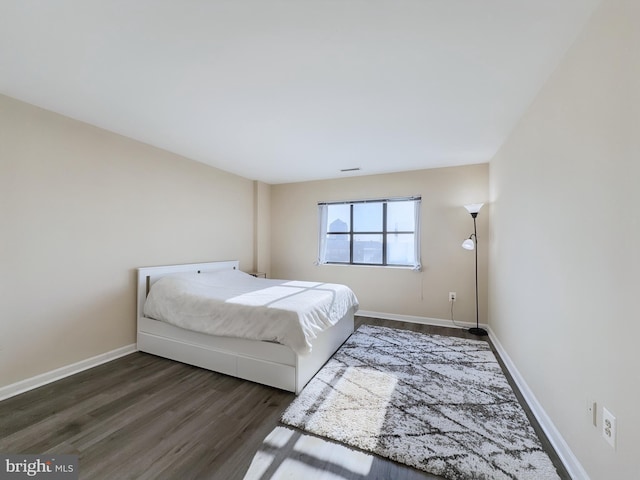 bedroom featuring dark wood-type flooring and baseboards